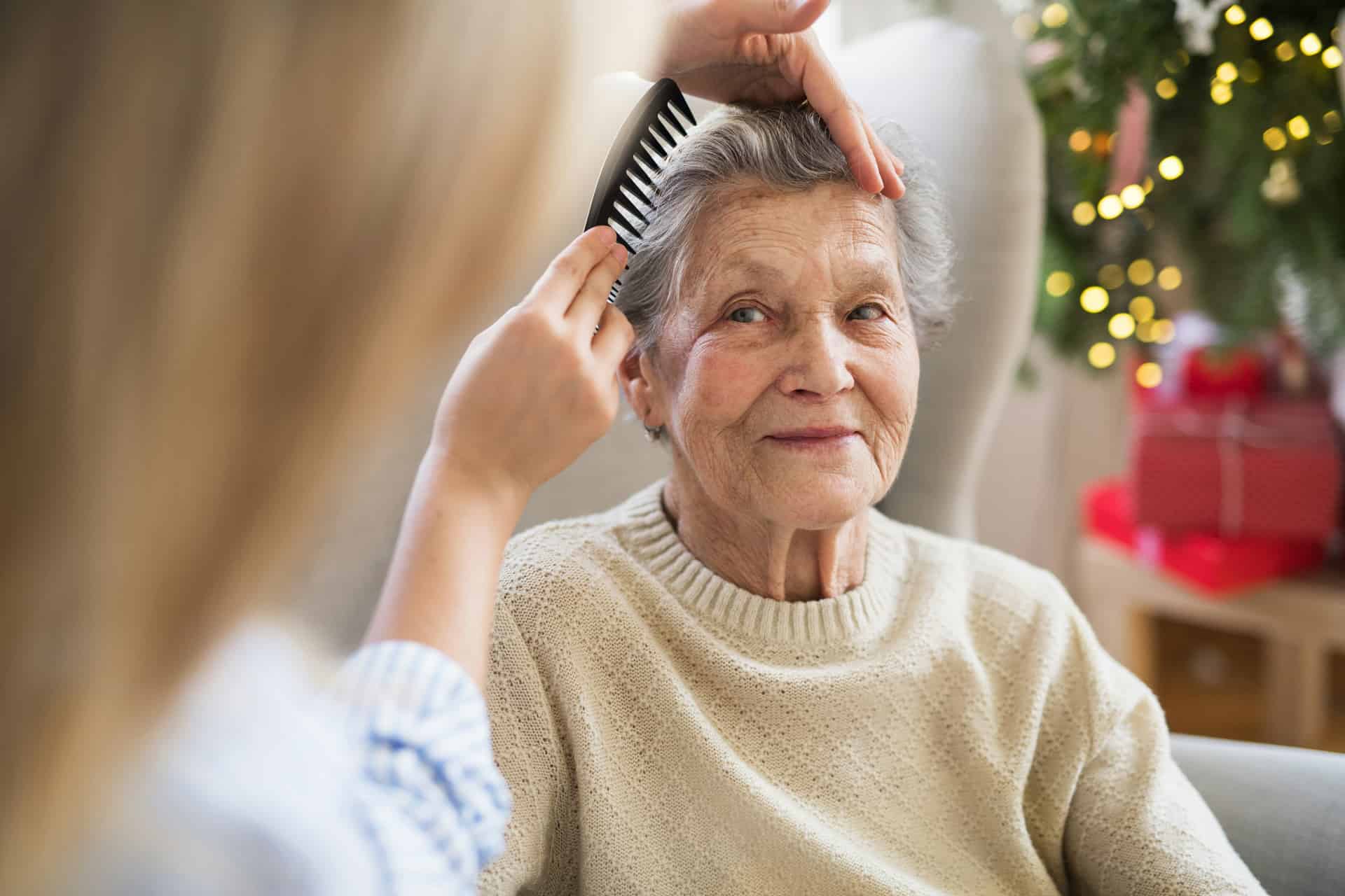 Caregiver gently combing a resident's hair