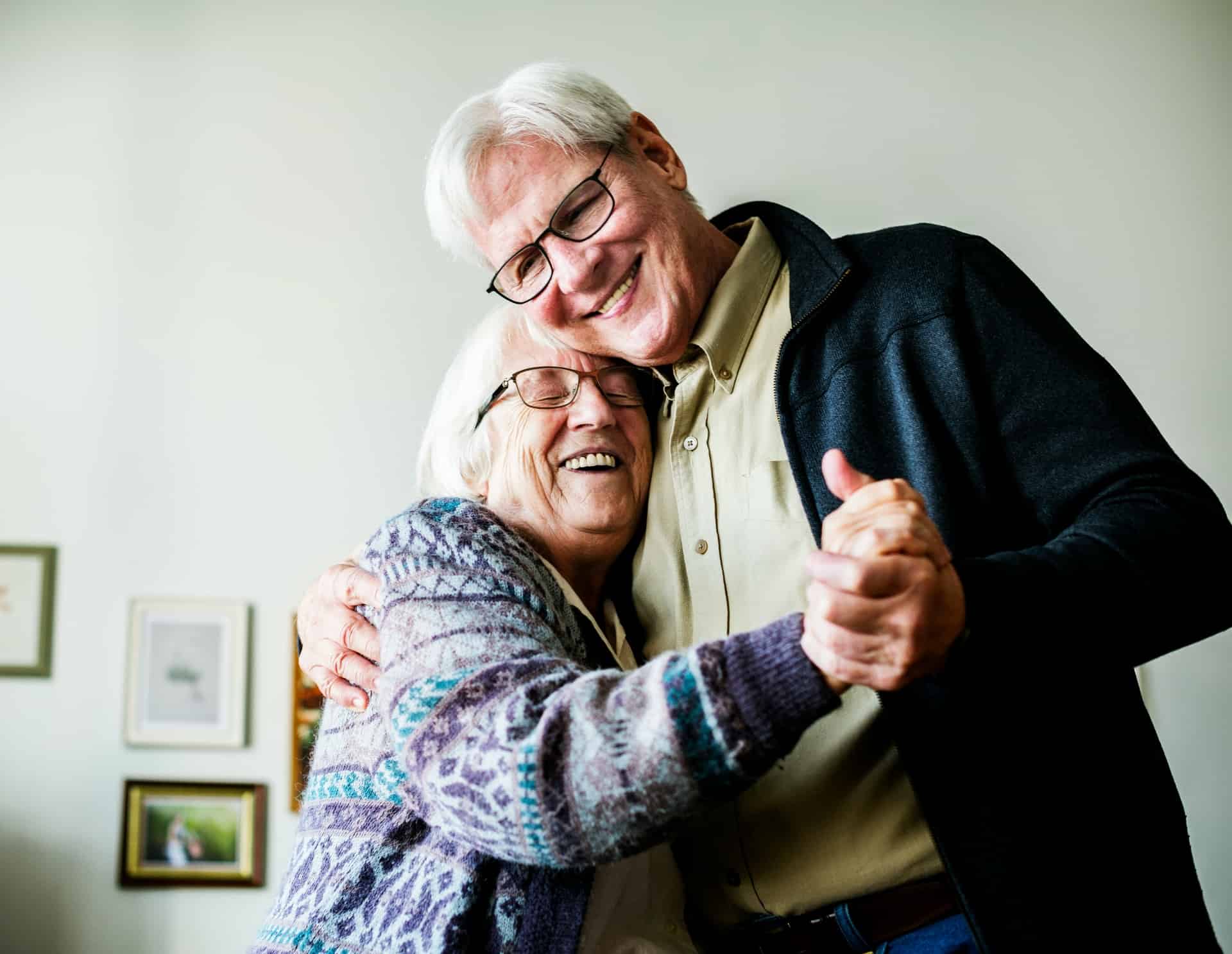 Elderly couple dancing together and smiling warmly